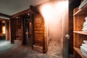 Open steam bath door with vapour beside the sauna and a towel shelf in the spa at Hotel Bellerive Zermatt