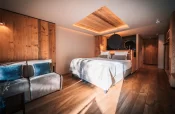 Lit double, canapé et plafond en bois à éclairage indirect dans la Deluxe Room, Hotel Bellerive Zermatt.