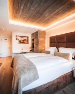 Chambre double Cosy Chic à l'Hôtel Bellerive Zermatt avec lit queen-size, plafond en bois et éclairage indirect