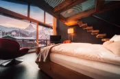 Overhead view of the Sky Room: fur throw on the bed, red chairs, floating wooden steps and the Matterhorn at sunset, Hotel Bellerive Zermatt.
