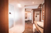 Bad der Junior Suite: zylindrische Glasdusche, Waschtisch mit ovalem Waschbecken und freistehende Wanne im Hintergrund.