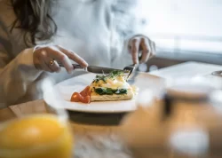 Assiette de petit-déjeuner avec œuf poché, épinards et hollandaise à table à l'Hôtel Bellerive Zermatt.