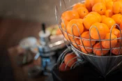 Fresh oranges in a wire basket on the juicer at the breakfast buffet of Hotel Bellerive Zermatt.