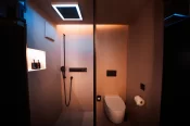 Walk-in shower with blue LED rain head and wall-hung WC in the Panorama Deluxe Room, Hotel Bellerive Zermatt.