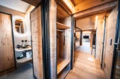 Lavabo avec miroir rond rétroéclairé et vue du couloir en bois, Alpine Nest 1895, Hôtel Bellerive Zermatt.