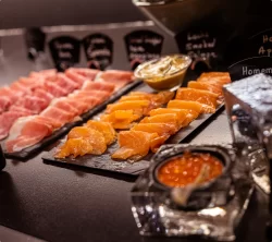 Buffet petit-déjeuner avec jambon, saumon fumé et caviar sur ardoises à l'Hôtel Bellerive Zermatt.