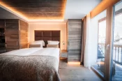 Cosy Chic double room with bed, wooden wardrobes and balcony access at Hotel Bellerive Zermatt