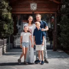 The Noti family at the glass door and Bellerive sign by the chalet entrance of Hotel Bellerive Zermatt.