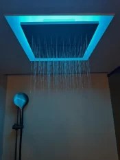 Douche pluie éclairée en LED turquoise et douchette dans la Deluxe Room, Hotel Bellerive Zermatt.