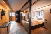 Espace nuit derrière une paroi vitrée, lit double et lumière chaude, Alpine Nest 1895, Hôtel Bellerive Zermatt.
